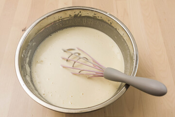 Manual whisk mixing cream and egg for cooking dessert