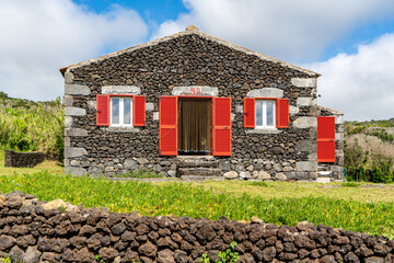 Fototapeta na wymiar Azores, on Island of Faial, Typical lava stone house in the Capelinhos area.