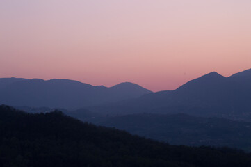 A pink sunset between the mountains.