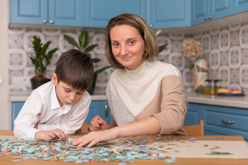 Home jigsaw puzzle. little boy and his mother playing