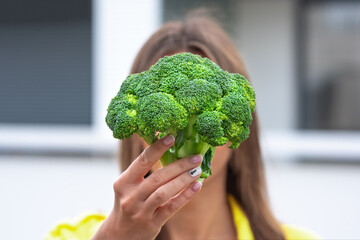 Woman holding broccoli in hands. Healthy plant based clean detox eating concept. Vegetarian, vegan, raw concept