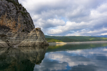 Fototapeta na wymiar Reflection of rocks in water on a cloudy day