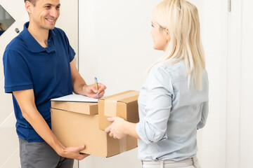 Fototapeta na wymiar Woman and courier during order transfer. Woman accepting delivery from deliveryman. Cropped image of delivery service worker giving parcel to client.