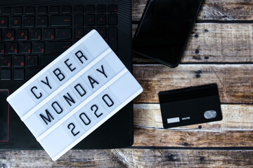 cyber monday word written on lightbox on brown wooden background. Flat lay, top view.