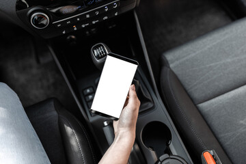 Interior view of a modern new car. A young woman using smartphone while driving the car
