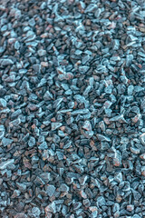 Small road stone with frozen background, dark gravel pebbles stone texture seamless texture, blurred scene with selective focus, shallow depth of the field