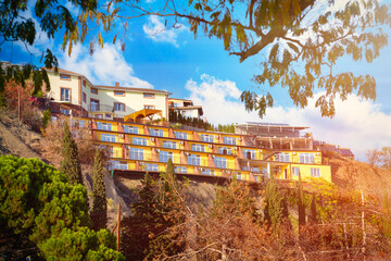 Colorful houses on the mountain . View through tree leaves