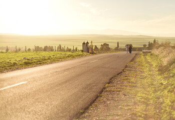 deux femmes marchant sur une route de campagne dans une atmosph&egrave;re baign&eacute;e de la lumi&egrave;re dor&eacute;e du coucher de soleil