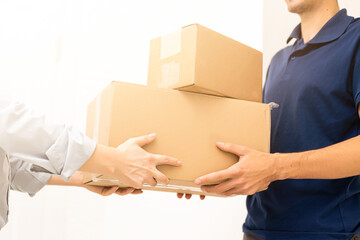 Smiling delivery man giving boxes to woman customer at home for online shopping service concept