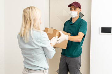 Obraz premium Woman and courier during order transfer. Woman accepting delivery from deliveryman. Cropped image of delivery service worker giving parcel to client.