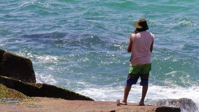 Homem pescando sobre a rocha