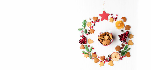 Christmas Decorative banner made of Festive Elements, gingerbread cookies, cranberries on white wooden background.