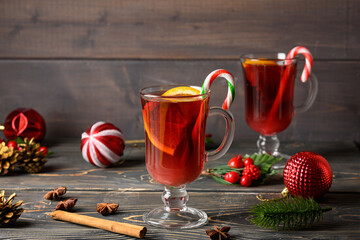 Two glasses with Christmas mulled wine, orange and caramel cane. Holiday atmosphere. Photo with copy space.