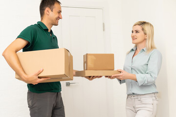 Smiling delivery man giving boxes to woman customer at home for online shopping service concept