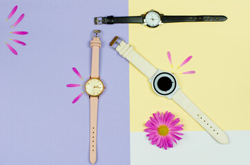 Stylish ladies watch on a colored background with flowers and place for text. Different colors clock