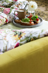 Breakfast of sandwiches with cottage cheese, avocado and tomatoes and coffee, served in bed.