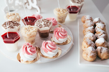 Banquet in the restaurant or cafe. Served table setting with fresh cupcakes sweets, candies with jelly and sugar. Gourmet tiramisu italian dessert birthday tasty chocolate. 
