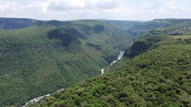 Vista a&eacute;rea de una barranca verde de &aacute;rboles y un r&iacute;o en el fondo