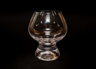 Glass shaped transparent wine glass close up on black background