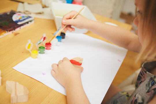 Child Painting. Happy Preschool Age Girl Holding A Brush Painting With Paint. Do It Yourself Project With Kids At Home. Shallow Dof