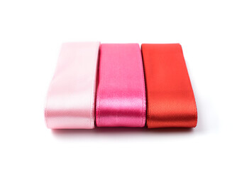 Silk ribbons in three colors on a white background. The concept of sewing accessories.