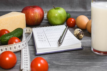 Diet plan. Notebook with notes about diet. Fat. Fresh vegetables, fruits, yoghurt and measuring tape on a rustic background. Ketogenic diet, healthly food. Close up.