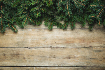Wooden background with Christmas tree branches and snow. Christmas concept. Banner. Flat lay, top view