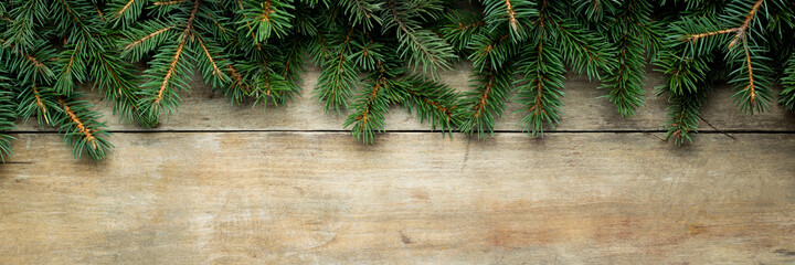 Wooden background with Christmas tree branches and snow. Christmas concept. Banner. Flat lay, top view