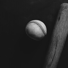 Old baseball bat and ball in moody black and white square.