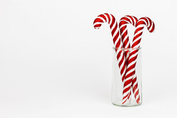 Christmas candy cans in transparent vintage style glass jar isolated on white background.
