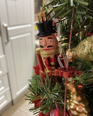 Christmas toy Officer hanging on the tree on the background of a white door.