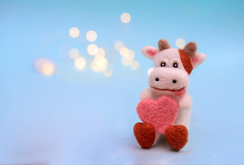 Felt toy bull with heart on a blue background