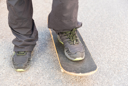 Close-up of man riding skateboard. Frontal view. Horizontal image.