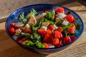 Tomato and cheese salad in a blue bowl