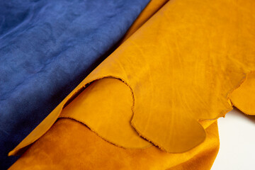 defocused huge rolls of natural brown and blue leather. Concept of materials for leather craft