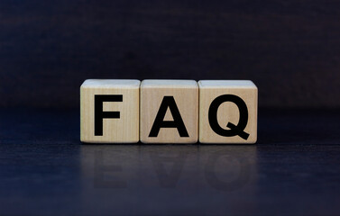 Concept word 'FAQ' on wooden cubes on a beautiful grey background. Business concept. Copy space.