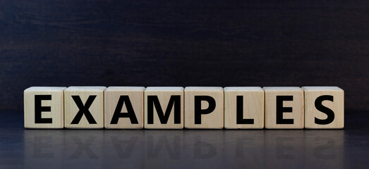 Concept word 'examples' on wooden cubes on a beautiful darl wooden background. Wooden table. Copy space. Business concept.