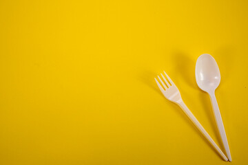 Plastic boat with a fork on a yellow background