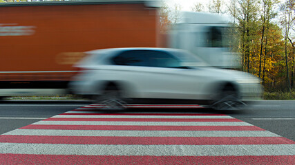 motion blurred image of fast driving car on road crosswalk