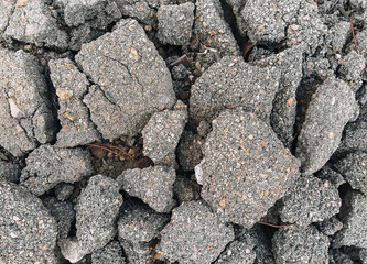 Texture, background of the destroyed, old, cracked in pieces of gray asphalt. Road works, earthquake underground.