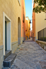Obraz premium A narrow street between the old houses of Pozzuoli, a town in the province of Naples, Italy.