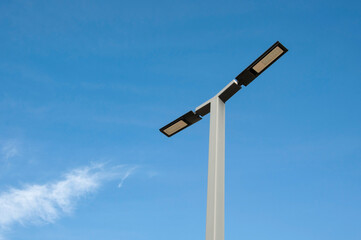 Naklejka na ściany i meble a metal design lamppost against a clear blue sky background