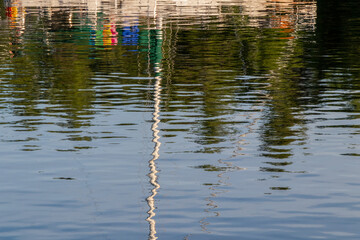 Colourful reflection of a sailboat in water