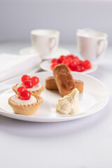 Selective focus . Dessert of cherry filled baskets with two almond fingers and sweet cherries.