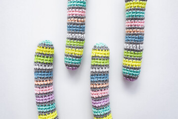 Women's hobby. Crochet and knitting. Knitted striped details on white background.
