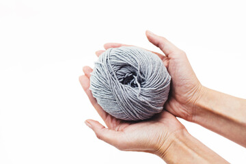  Women's hobby. Crochet and knitting. Working space. Gray yarn the in hands on the yellow background. Hobby