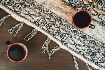 Top view of two coffee glasses on a wooden table. The tablecloth fabric. Warm atmosphere.