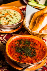 Traditional Georgian soup Kharcho with meat and rice. Fresh bread and vegetable mix background. Vertical orientation.