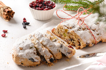 Christmas stollen with raisin, cranberry and candied fruit on white. Close up.