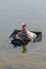 An old, lamp-broken TV thrown into a pond by someone